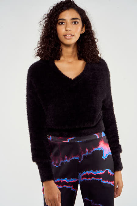 Pull noir à col V de NOOR BY NORA GHARIB, en tissu doux et moelleux.