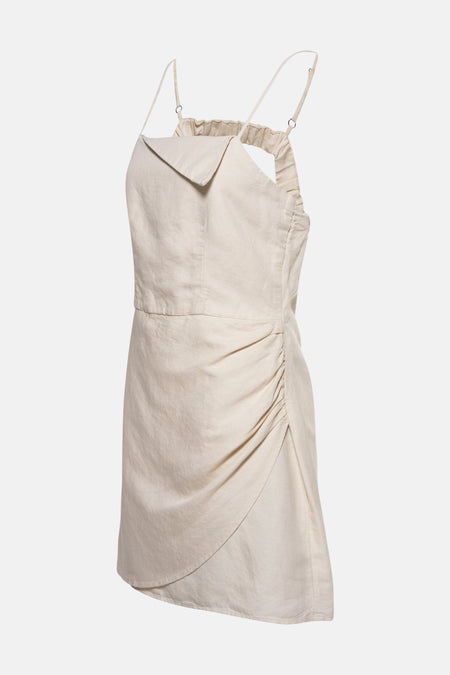 Petite robe écru d'OXXO, avec des rubans spaghetti et des détails froncés sur les côtés.