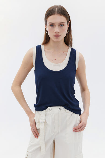 Blauwe tanktop van OXXO, gedragen met een crèmekleurige top en cargobroek.
