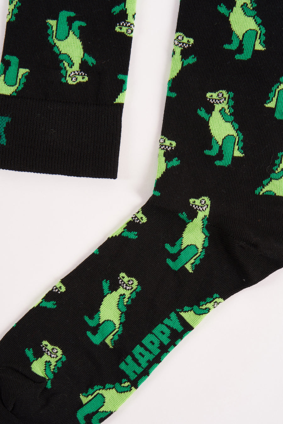 Zwarte sokken van Happy Socks, met een groen dinosauruspatroon en het woord "HAPPY" erop gedrukt.
