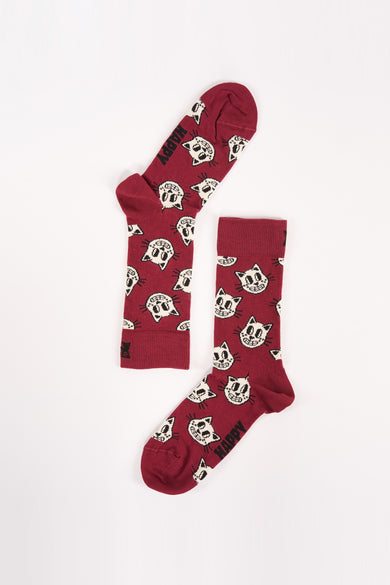 Donkerrode sokken met witte katjesprint van Happy Socks, gestreepte rand en "HAPPY" tekst op teen, plat gelegd op witte achtergrond