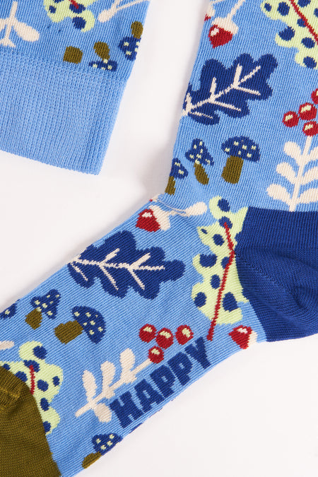 Blauwe sokken met bosmotief van Happy Socks, met paddenstoelen, bessen en groene planten, close-up weergave