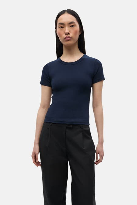 Blauw T-shirt met korte mouwen van ENVII, gecombineerd met een zwarte pantalon tegen een witte achtergrond.
