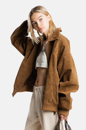 Manteau court brun de ANOTHER COTTON LAB, avec une fermeture avant ouverte, associé à un haut blanc et à des pantalons beige.
