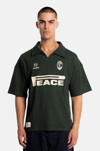 Polo verte à manches courtes de couleur verte de ANOTHER COTTON LAB, avec imprimé "PEACE" et logos sur la poitrine.