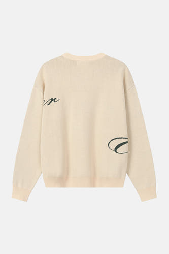Pull beige à col rond de ANOTHER COTTON LAB, avec lettres vert foncé sur la manche et le côté.