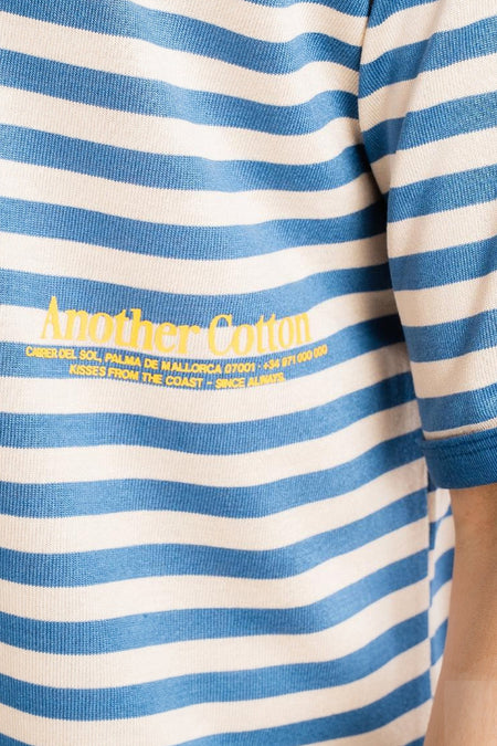 Blauw-wit gestreepte korte mouwen t-shirt van Another Cotton Lab met gele tekstprint, close-up van borst en mouw.