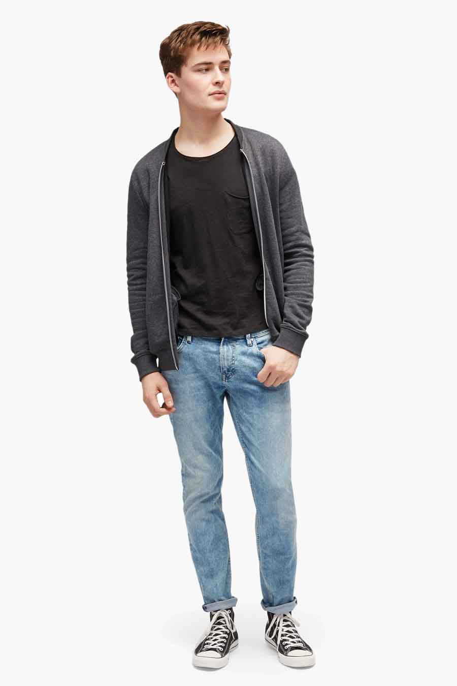 Jean slim en denim de Tom Tailor, avec un délavage clair et des jambes retroussées, combiné avec un t-shirt noir et un cardigan gris.