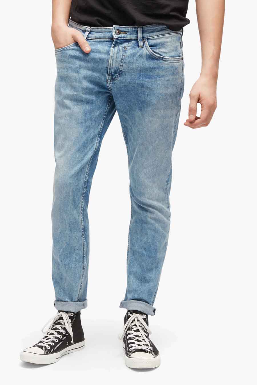 Jeans slim en denim de TOM TAILOR, avec un délavage clair et associé à des baskets en toile noires.