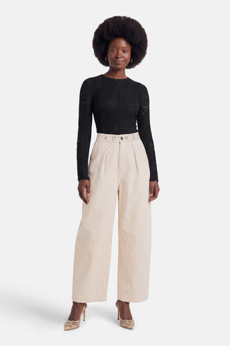 Ecru chino broek van ADORE met hoge taille, plooien en breed been, gedragen met zwarte top en gouden hakken
