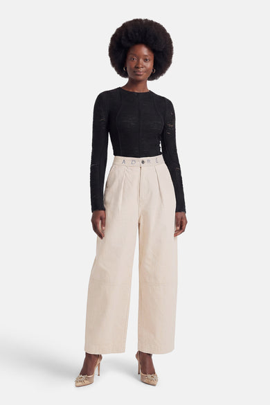 Ecru chino broek van ADORE met hoge taille, plooien en breed been, gedragen met zwarte top en gouden hakken