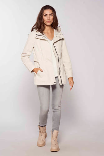 Jean skinny gris de Pepe Jeans, associé à une veste beige et des bottes à fermeture éclair.