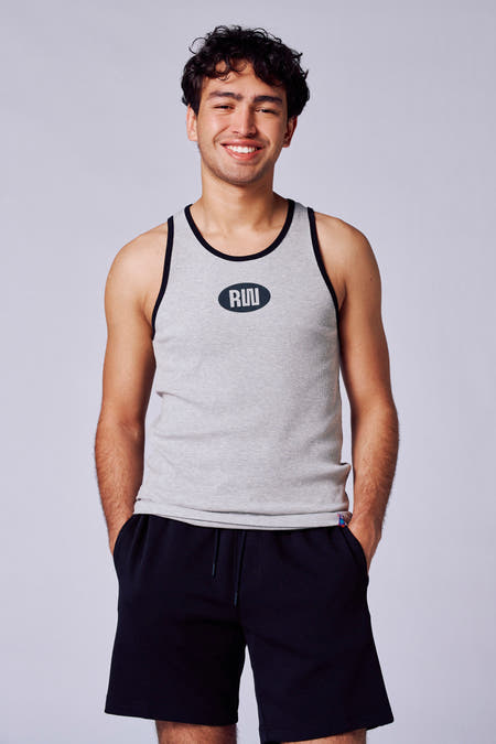 Grijs singlet van Rock Werchter 50, met zwarte bies en logo, gedragen met zwarte shorts.

