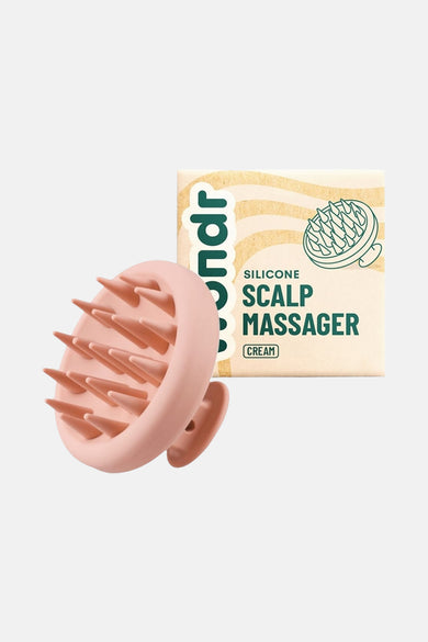 Roze verzorgingsproduct van WONDR CARE, met siliconen punten, naast de productverpakking.