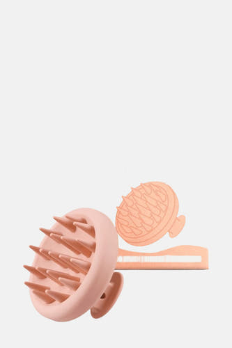Brosse de soin rose WONDR CARE, avec une forme ronde et des poils doux.