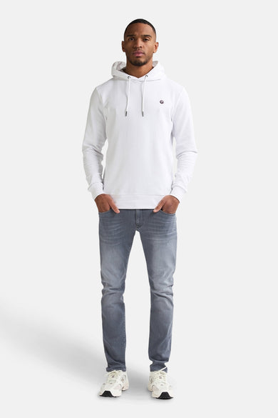 Jean slim de denim gris clair de Petrol Industries®, porté avec une hoodie blanche et des baskets.