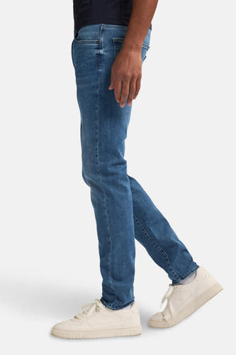 Jean en denim bleu clair slim fit de Petrol Industries, avec des points visibles et des chaussures décontractées.