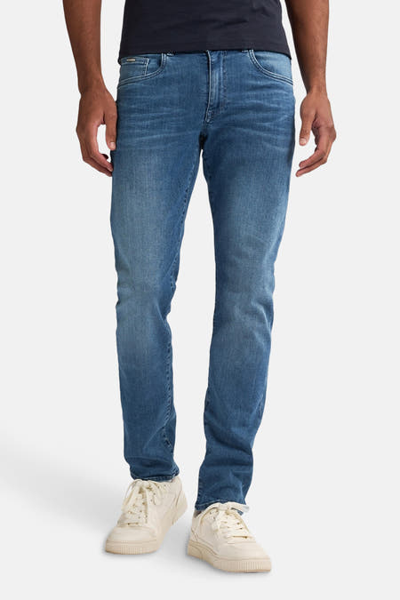 Slim fit jeans van lichtblauw denim van Petrol Industries, gedragen met witte sneakers.