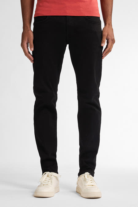 Jean slim-fit noir de Petrol Industries avec des poches arrière et une étiquette en cuir sur la ceinture.