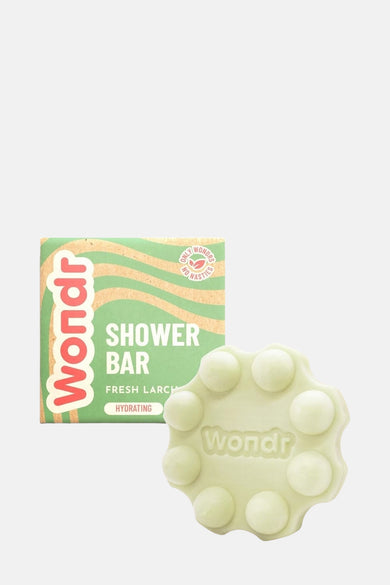 Groene douchegel van WONDR CARE, met ronde uitstulpingen en verpakking met golvend patroon.
