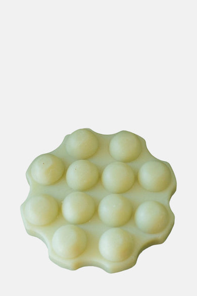 Groene douchegel van WONDR CARE, met een gegroefd en bolvormig ontwerp.