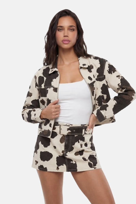 Korte jas met beige en bruine koeienprint van TALLY WEIJL, met rits, gedragen over een witte top met bijpassende minirok.