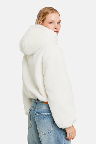 Manteau court blanc de TALLY WEIJL, avec capuche, associé à un jean.
