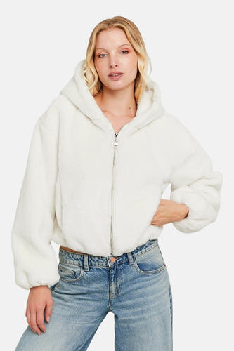 Manteau blanc de TALLY WEIJL, avec des manches longues et un capuchon, associé à des jeans bleus.