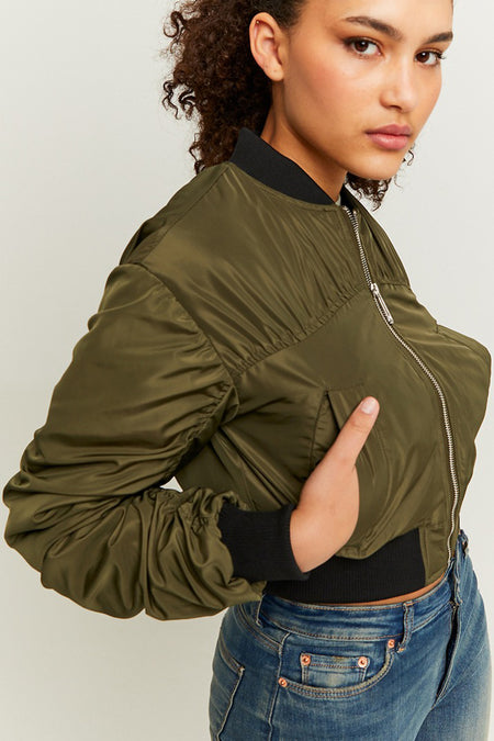 Groene korte jas van TALLY WEIJL, met een rits en gedragen met een blauwe jeans.
