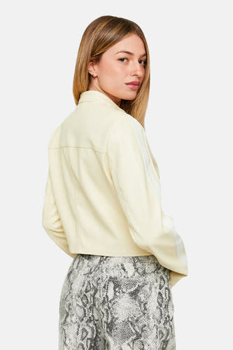 Manteau de cuir écru TALLY WEIJL, avec une bande blanche sur le manche, associé à un pantalon à imprimé serpent.