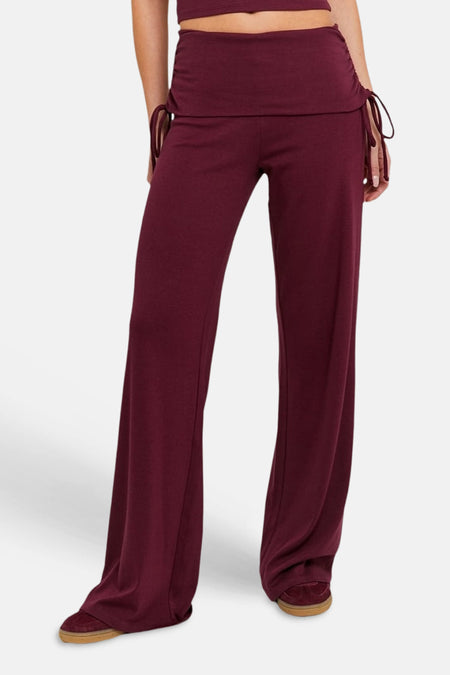 Bordeaux joggingbroek van TALLY WEIJL met wijde pijpen, trekkoorden aan de taille en gedragen met sneakers.