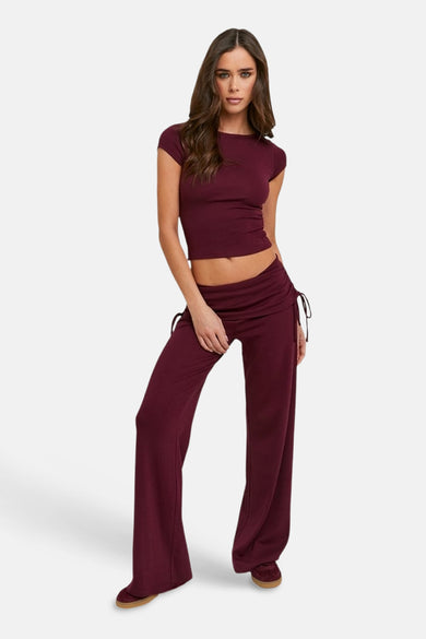 Pantalon de jogging Bordeaux de TALLY WEIJL avec cordons de serrage sur le côté, porté avec un crop top assorti.