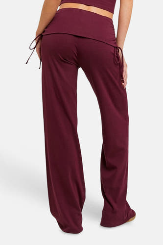 Bordeaux joggingbroek van TALLY WEIJL met fold-over tailleband, wijde pijpen en trekkoorden aan de zijkant, in achteraanzicht.