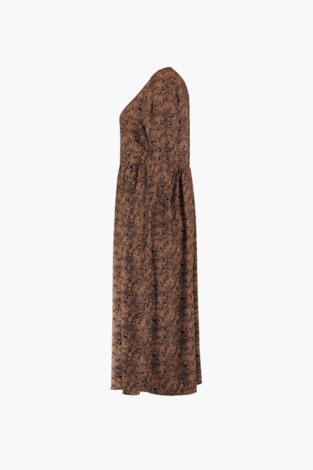 Cognac kleurige jurk met lange mouwen van Zabaione, met een abstract zwart patroon.