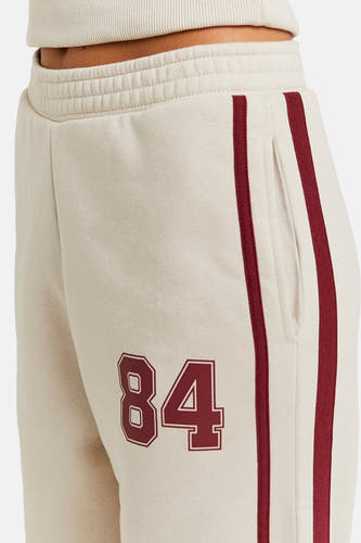 Pantalon de jogging beige TALLY WEIJL, avec des rayures bordeaux et le numéro 84, vue arrière.