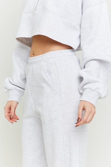 Jean de jogging gris TALLY WEIJL, avec poches et ceinture, porté avec un crop top coordonné.