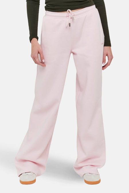 Roze joggingbroek met wijde pijpen, groen shirt.
