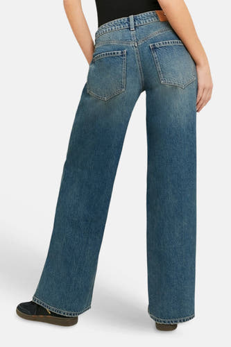 Lichtblauwe spijkerbroek met wijde pijpen van TALLY WEIJL, achterkant zichtbaar, met lichte fading en opgestikte achterzakken, gedragen met sneakers.