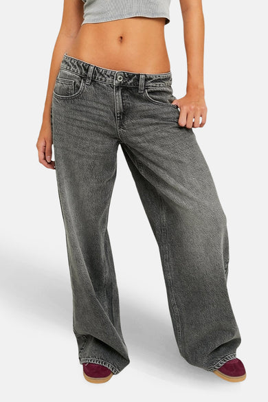 Jean en denim gris large de TALLY WEIJL, avec des jambes larges et des chaussures rouges.