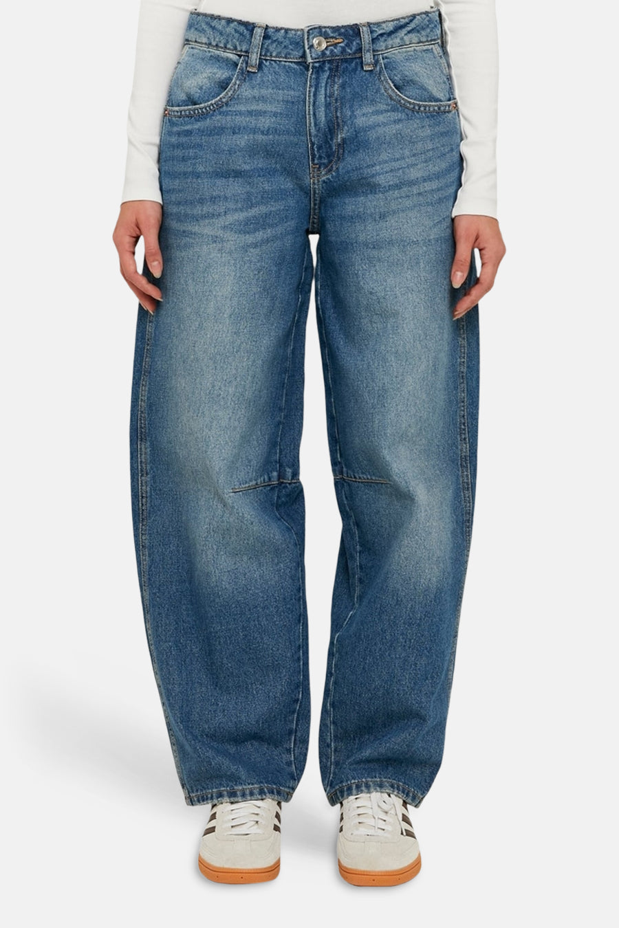 Jean bleu coupe spéciale en denim, de TALLY WEIJL, à jambes larges et baskets beiges.