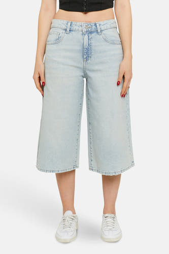 Korte, lichtblauwe denim broek van TALLY WEIJL, met wijde pijpen en witte sneakers.