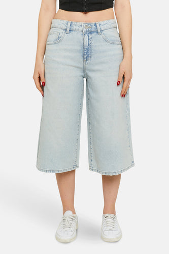 Korte, lichtblauwe denim broek van TALLY WEIJL, met wijde pijpen en witte sneakers.