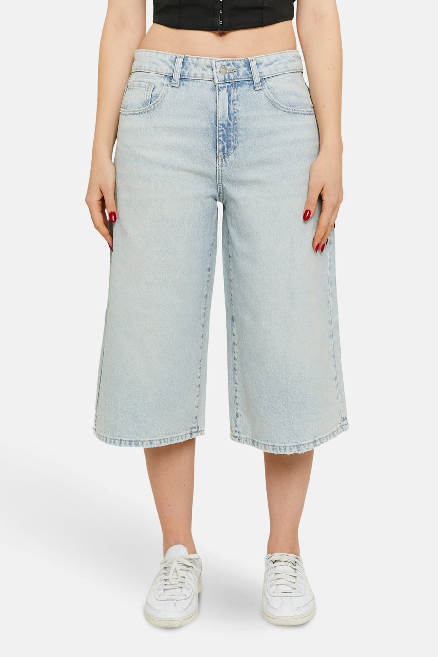 Korte, lichtblauwe denim broek van TALLY WEIJL, met wijde pijpen en witte sneakers.