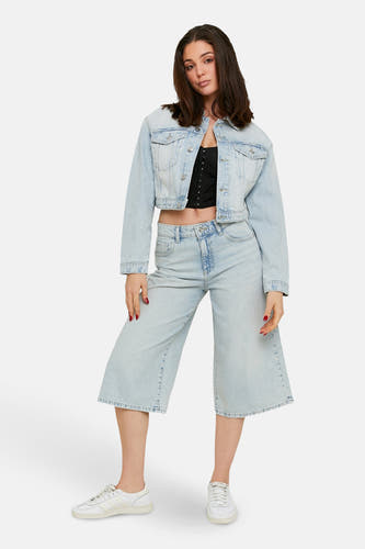 Korte lichtblauwe denim short van TALLY WEIJL, gecombineerd met een zwart topje en een denim jas.
