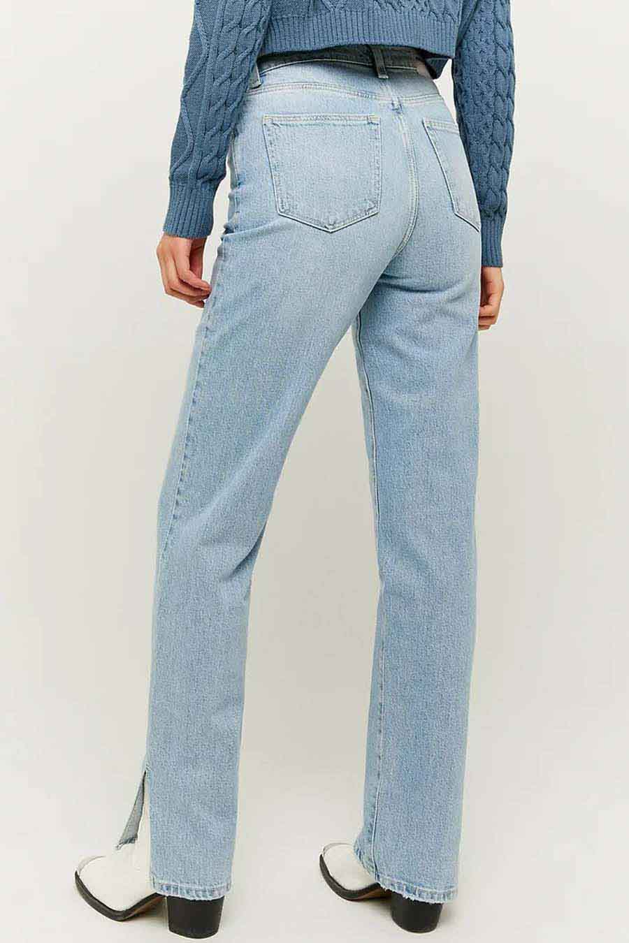 Lichtblauwe straight jeans van TALLY WEIJL, met splitjes aan de onderkant, gecombineerd met een blauwe trui en witte laarsjes.