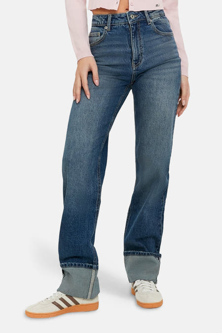 Wijde jeans van blauw denim van TALLY WEIJL, met omgeslagen pijpen en verder gecombineerd met een roze vest en witte sneakers.
