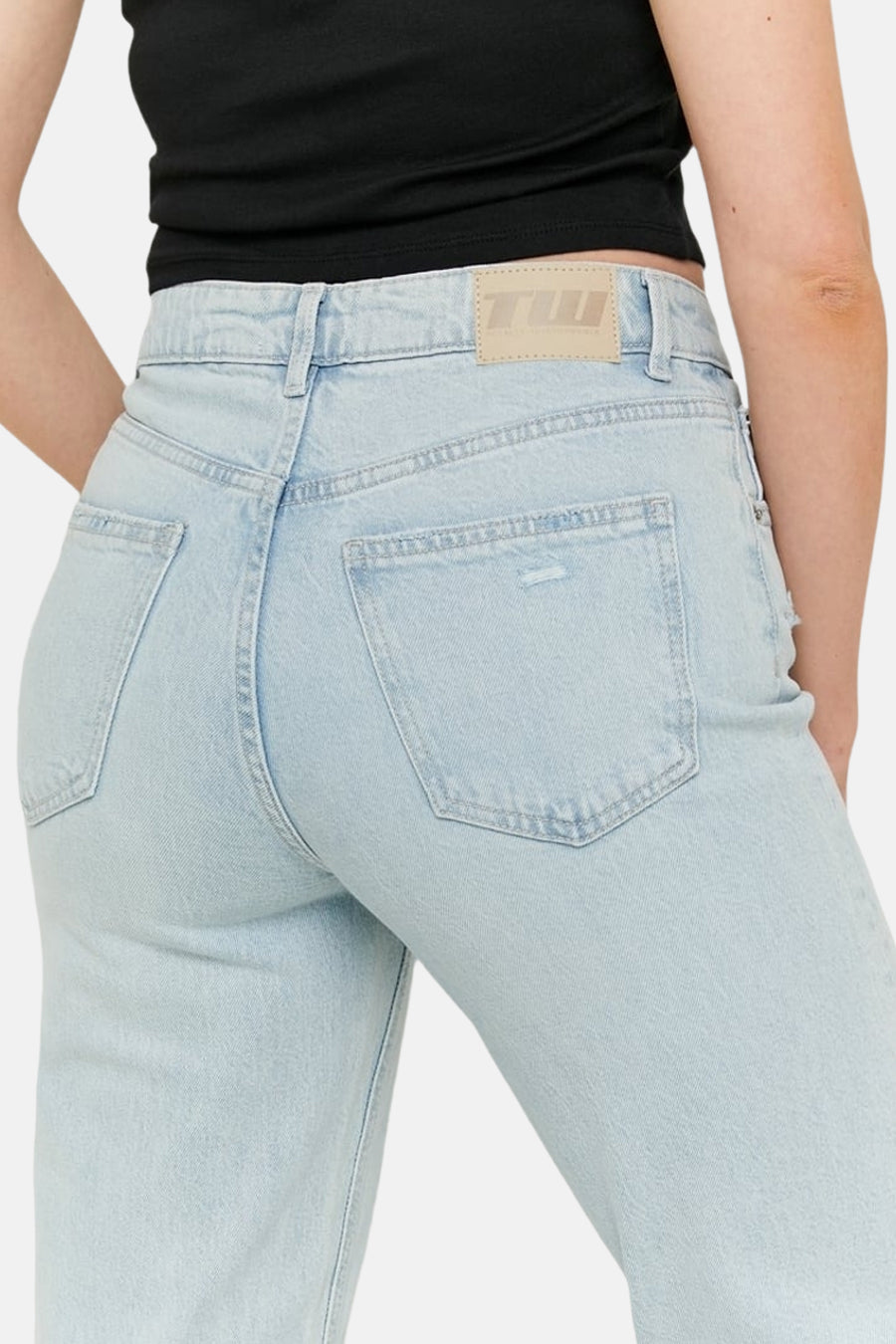Jean droite bleu clair de TALLY WEIJL avec poches arrière et un patch beige sur la ceinture.