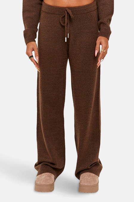 Bruine broek van TALLY WEIJL, met een trekkoord en wijde pijpen, gecombineerd met beige pantoffels.
