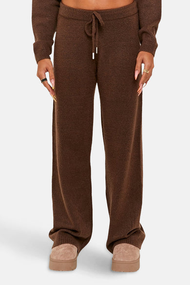 Bruine broek van TALLY WEIJL, met een trekkoord en wijde pijpen, gecombineerd met beige pantoffels.
