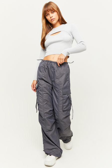 Grijze cargobroek van TALLY WEIJL, met zakken en trekkoorden, gecombineerd met een grijze top en witte sneakers.
